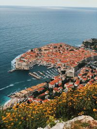 High angle view of townscape by sea against sky