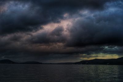 Scenic view of sea against storm clouds