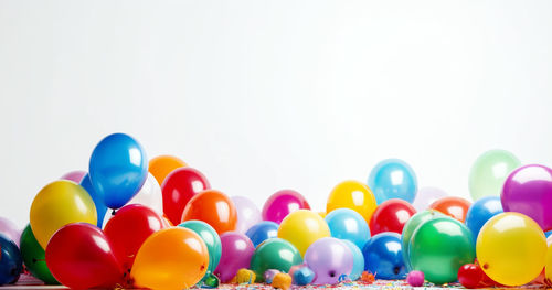 Close-up of multi colored balloons against white background