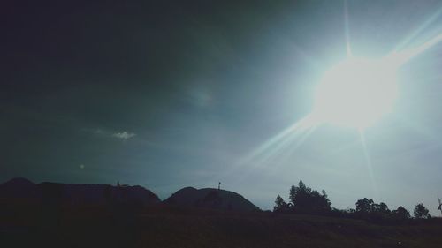 Scenic view of bright sun over landscape against sky