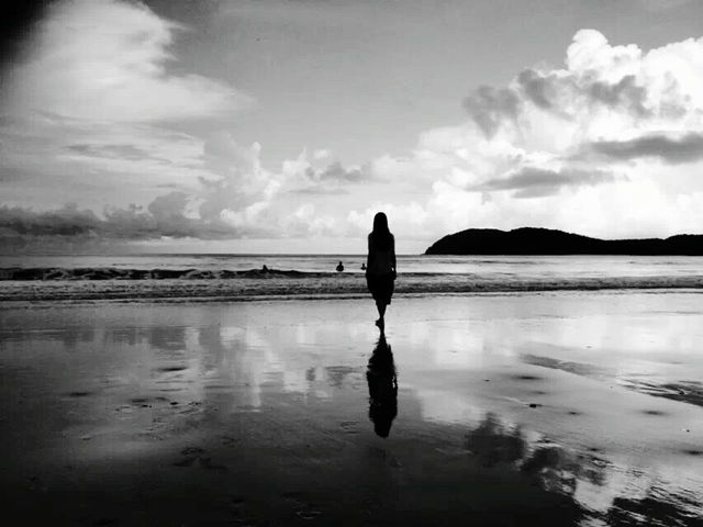 Silhouette of woman standing on beach | ID: 85418051
