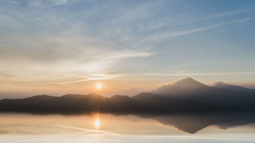 Scenic view of silhouette mountains against sky during sunset