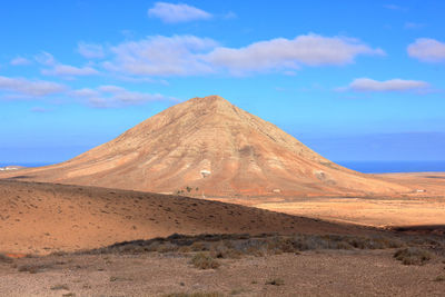 View of desert against cloudy sky