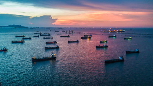 Boats on sea against sky during sunset