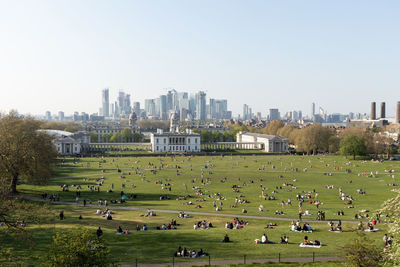 Group of people in park against buildings in city