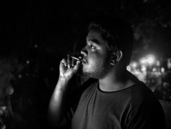 Portrait of young man drinking glass outdoors