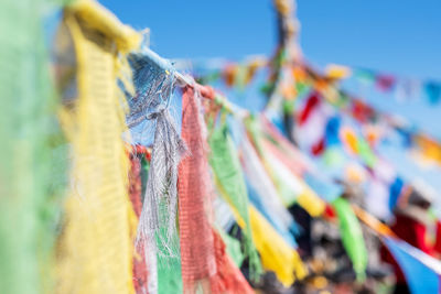 Low angle view of flags hanging against blue sky