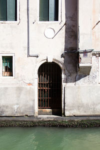 Frontal shot of the exterior of an old building  while the gate is close to the water