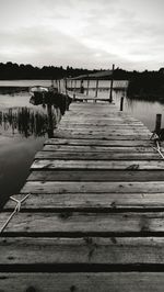 Wooden pier on lake against sky