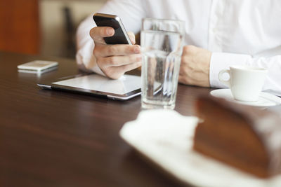 Midsection of man using laptop on table