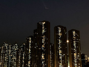 Low angle view of illuminated buildings against sky at night