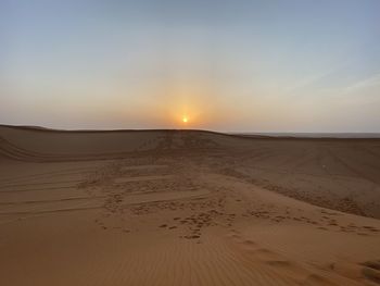 Scenic view of desert against sky during sunset