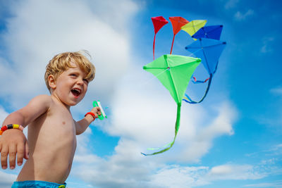 Low angle view of young woman with umbrella against sky