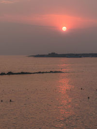 Scenic view of sea against orange sky