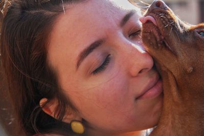 Close-up of young woman with dog outdoors
