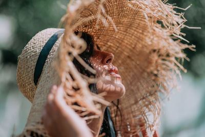 Portrait of young woman holding hat