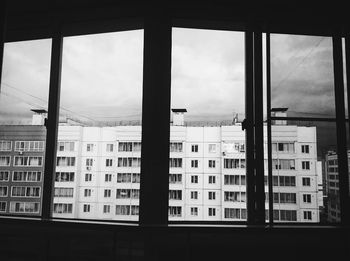 Buildings in city seen through glass window