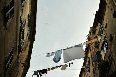 Low angle view of clothes drying against sky