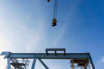 Low angle view of overhead cable cars against sky