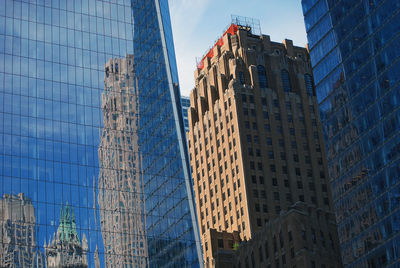 Low angle view of modern buildings against blue sky