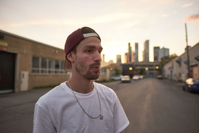 Young skateboarder exhaling cigarette smoke in downtown urban ar