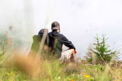 Rear view of couple sitting on field
