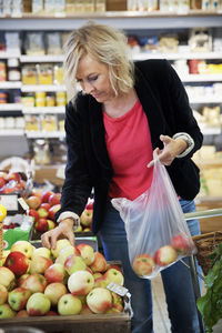 Mature woman choosing apples