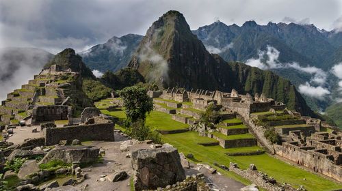 High angle view of old ruins against cloudy sky