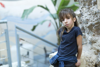 Portrait of girl standing against rock