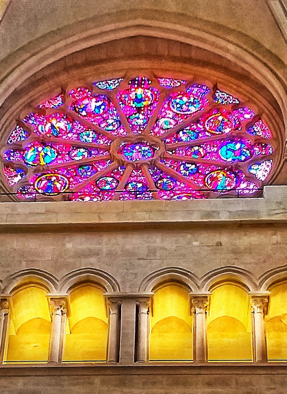 LOW ANGLE VIEW OF ORNATE GLASS WINDOW IN CEILING
