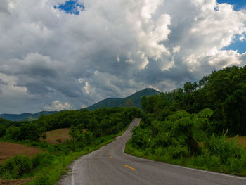 Road leading towards mountains against sky