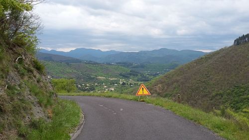 Road amidst mountains against sky