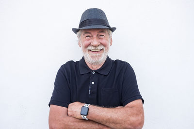 Portrait of senior man wearing hat against white background