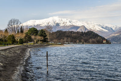 The lakeside promenade of colico with the snow-capped alps in the background