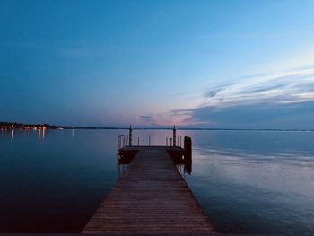 Pier over sea against sky during sunset