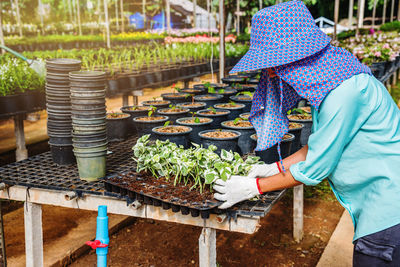 Rear view of woman holding umbrella at farm