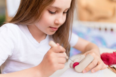 Felt wool craft handmade needle. little kid girl artisan hand makes creative toy made of sheep hair