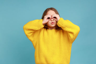 Portrait of a beautiful young woman against blue background