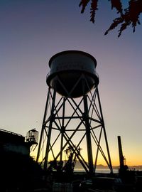 Low angle view of water tower against clear sky at sunset