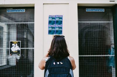 Rear view of woman standing with text