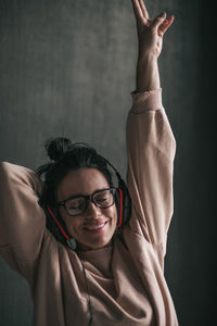 Portrait of smiling woman against wall