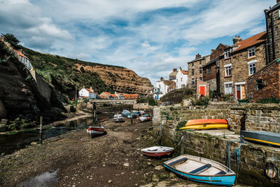 Boats moored on shore against sky
