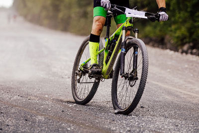 Cyclist rider on mountain bike downhill on gravel road cross-country competition