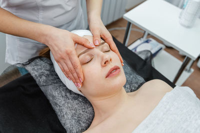 Woman under facial treatment at salon. procedure of facial massage.