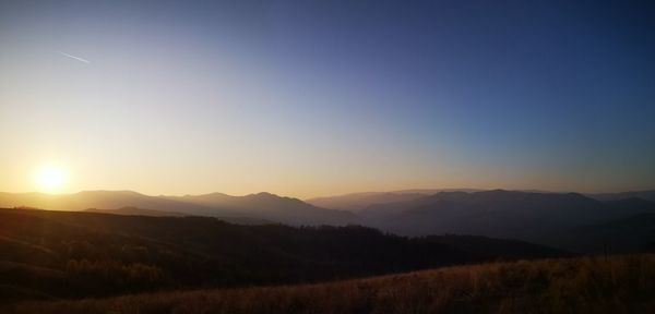 Scenic view of mountains against clear sky during sunset