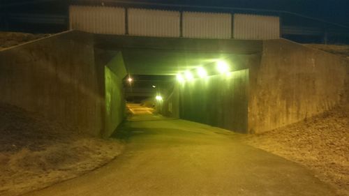 Illuminated tunnel at night