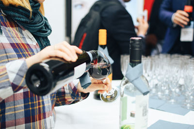 Midsection of woman holding wine glass