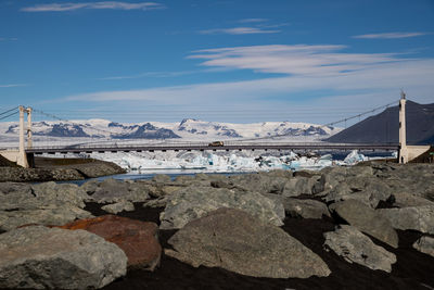 Bridge against snowcapped mountains