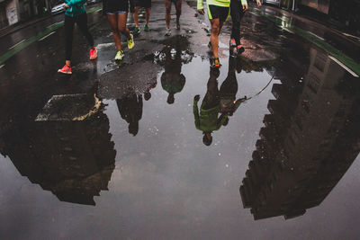 Low section of man walking on wet street