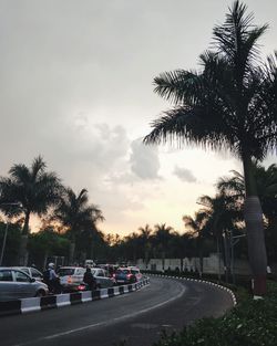 Cars on road against sky during sunset